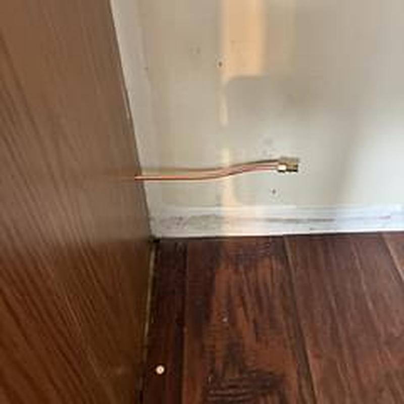 Refrigerator ice maker water line installation pointing wall