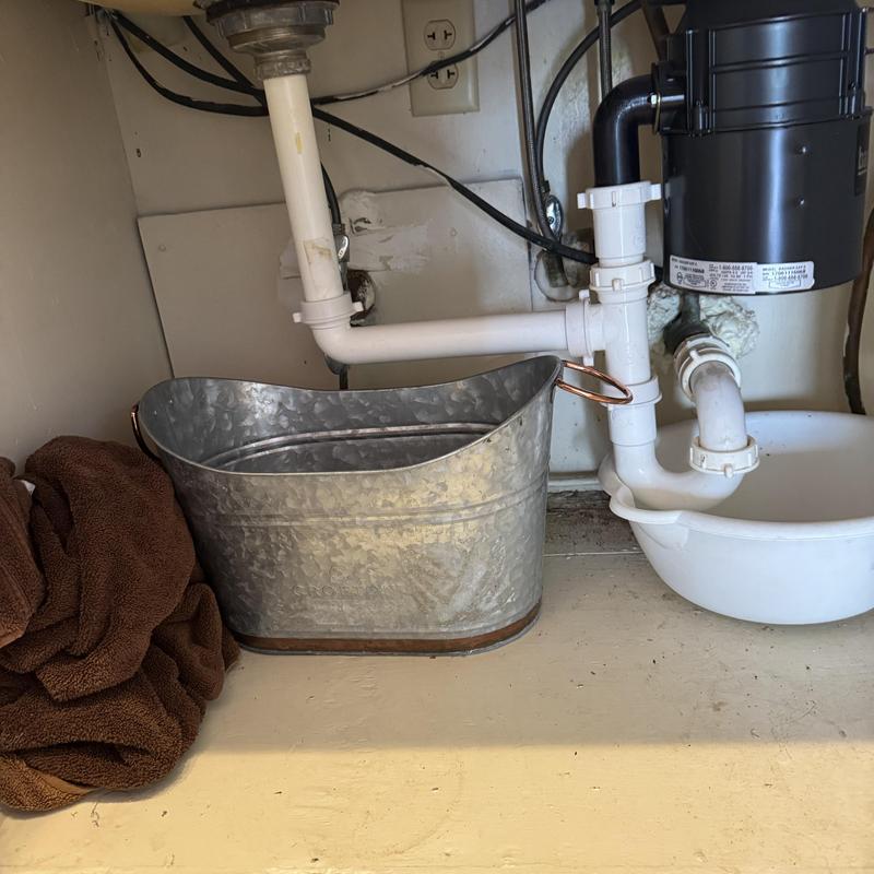 Kitchen sink drain and pipes with bucket underneath
