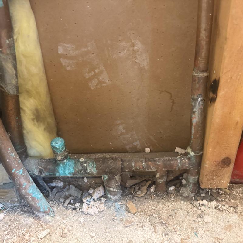 Copper water line manifold with corrosion and debris buildup