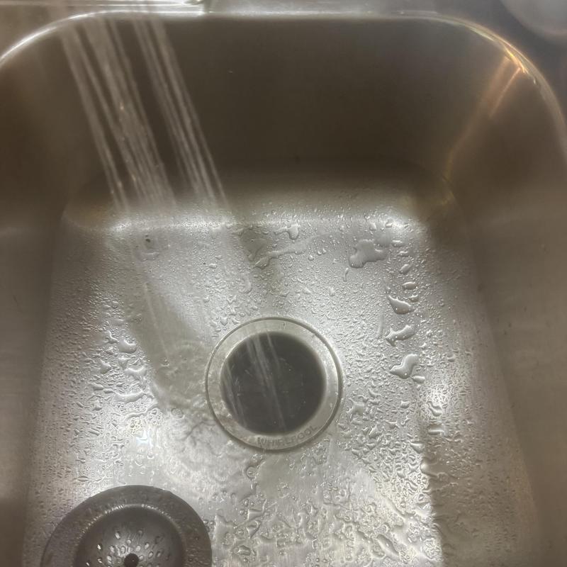 Kitchen sink drain with running water and droplets