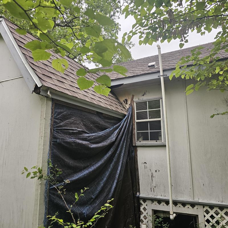 Roof shingles with hail damage and tarp cover