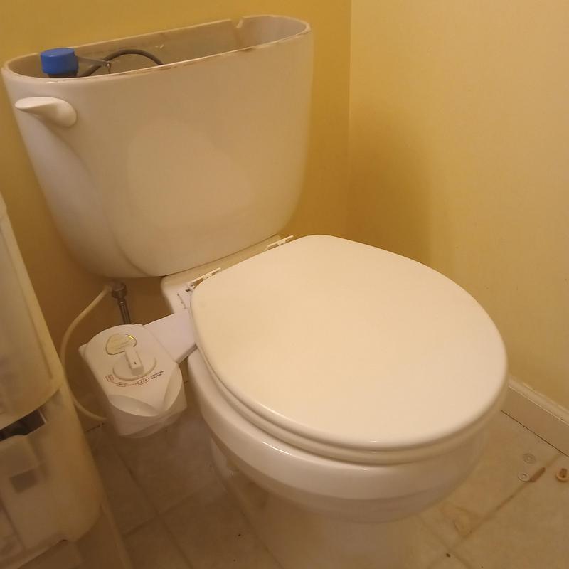 Toilet tank with open lid and bidet attachment installation Toilet tank with open lid and bidet attachment installation