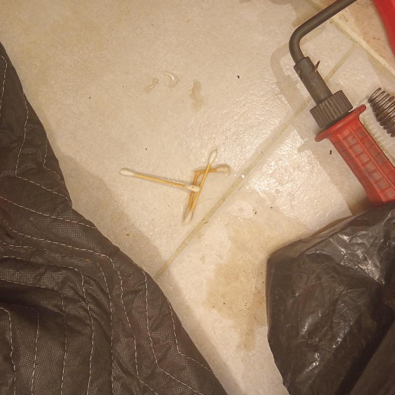 Drain auger tool with red handle on tiled floor Drain auger tool with red handle on tiled floor