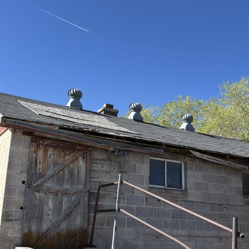 Asphalt shingle roof with damage near wooden door