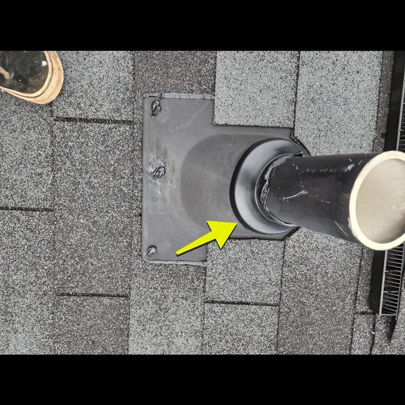 Pipe boot on gray shingle roof with arrow marker
