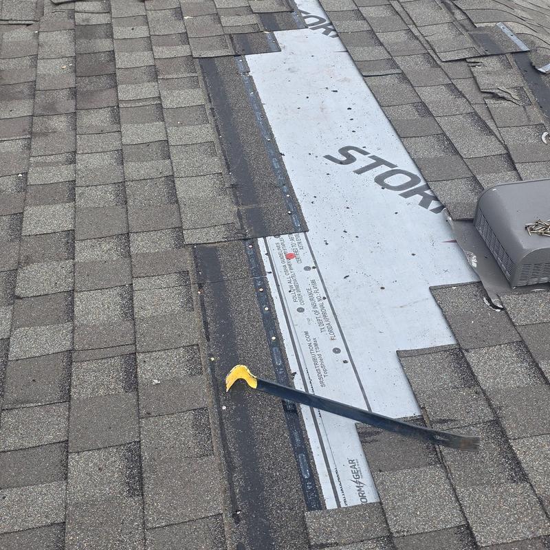 Asphalt shingles roof with exposed underlayment and pry bar