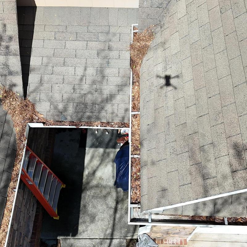 Gutter system filled with leaves and debris on roof edge