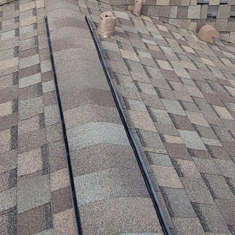 Asphalt shingle roof with ridge vent and pipe flashing