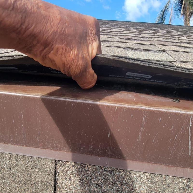 Shingle roof edge inspection showing lifted shingles