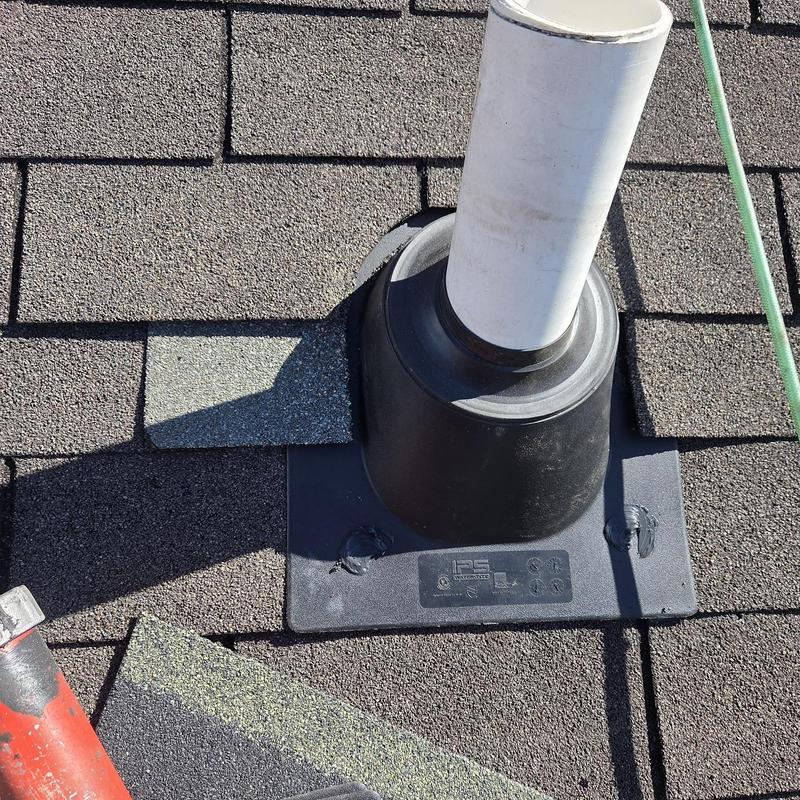 Pipe boot and shingles with fresh caulking on roof