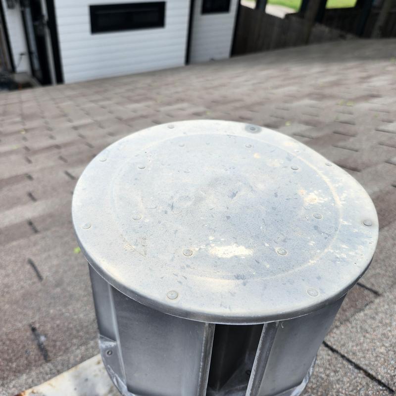 Roof vent cap on shingle roof with hail damage