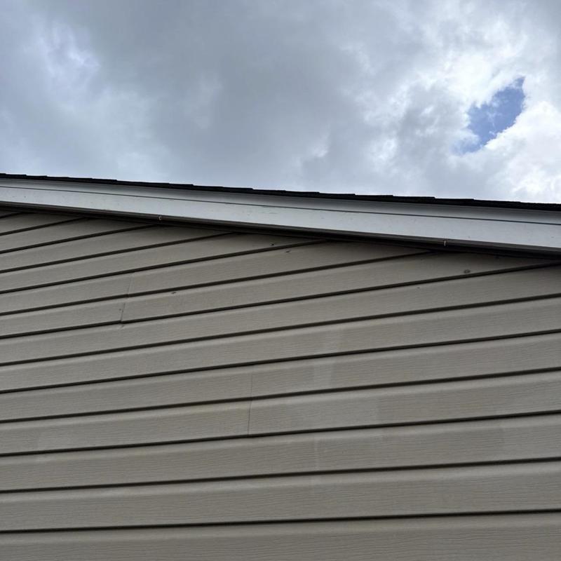 Vinyl siding panels with wind damage on house exterior Vinyl siding panels with wind damage on house exterior