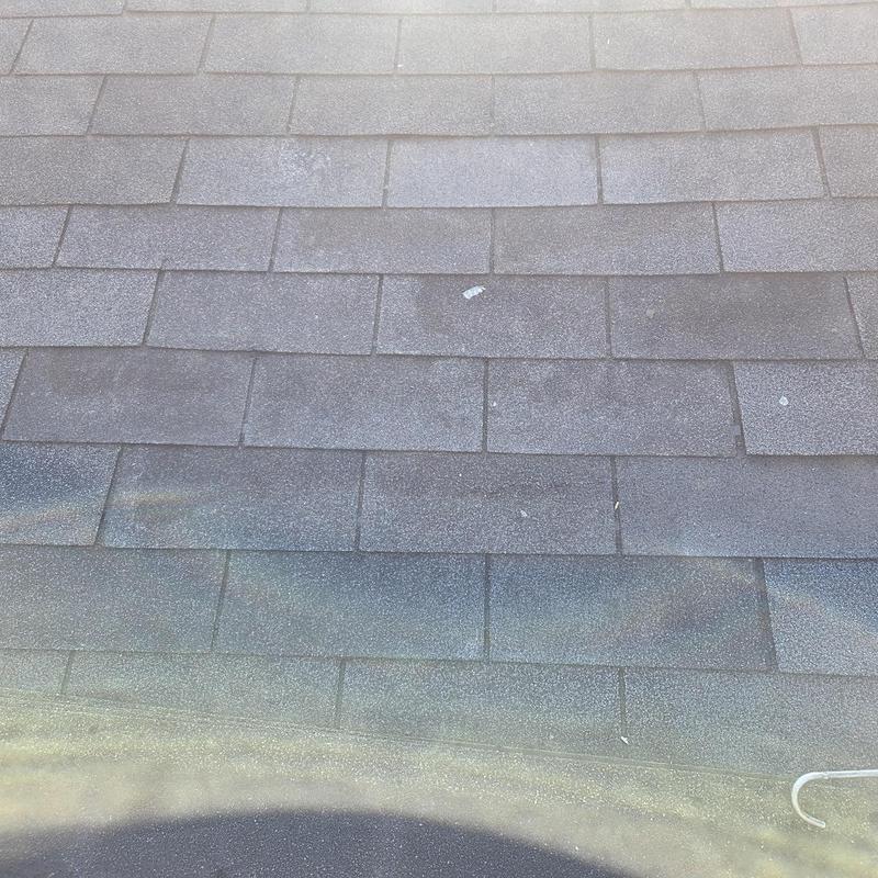 Asphalt shingles with new replacements on roof