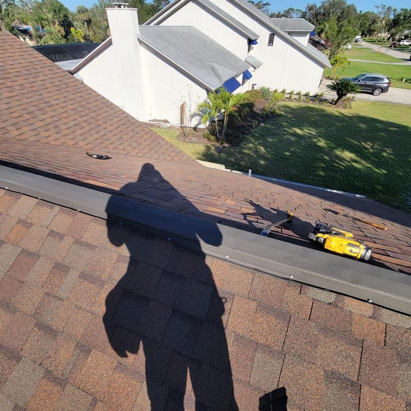 Shingle roof with nail gun and tool on site