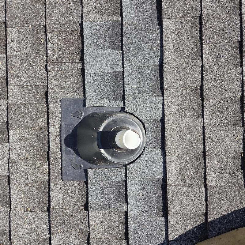 Pipe boot with new shingles on asphalt roof