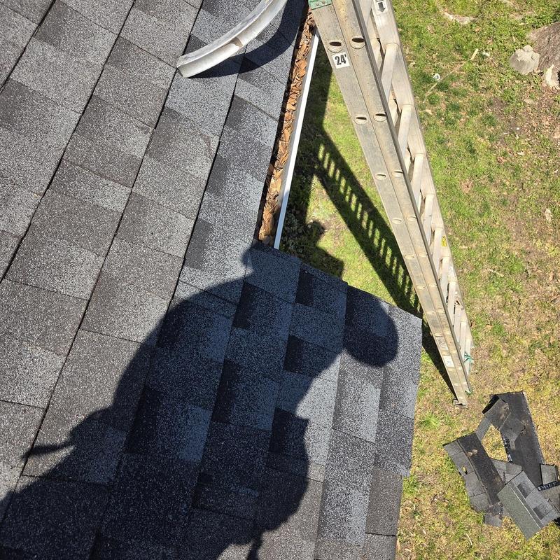 Roof shingles on front corner with ladder and debris