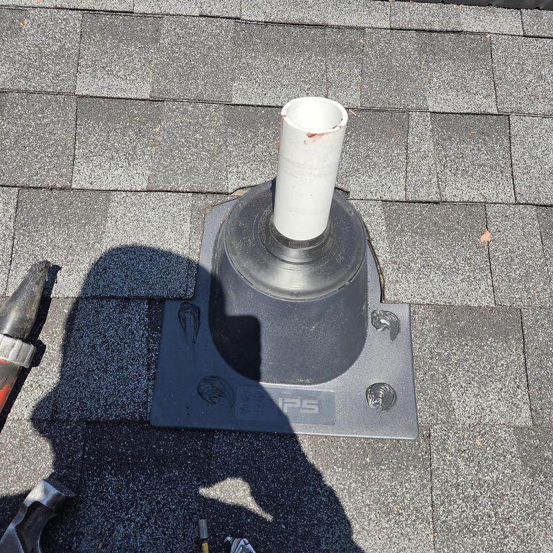 Pipe boot on shingled roof with caulking applied