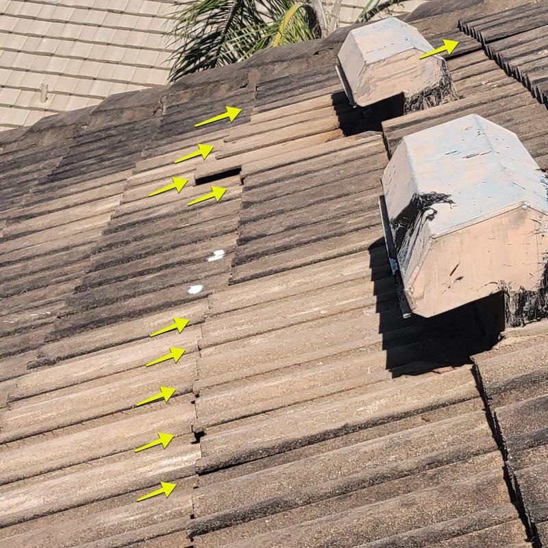 Concrete tile roof with multiple cracked and missing tiles