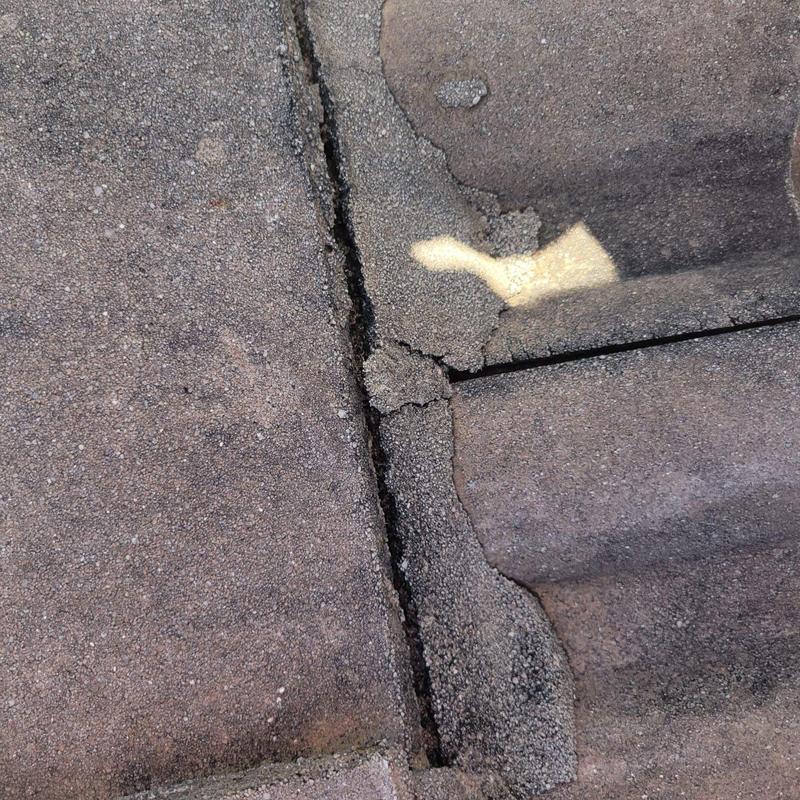 Concrete tile roof damaged and cracked close-up view