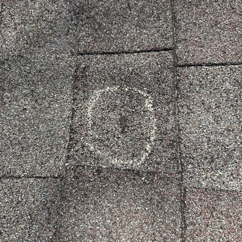 Asphalt shingle roof with hail damage marked for inspection Asphalt shingle roof with hail damage marked for inspection