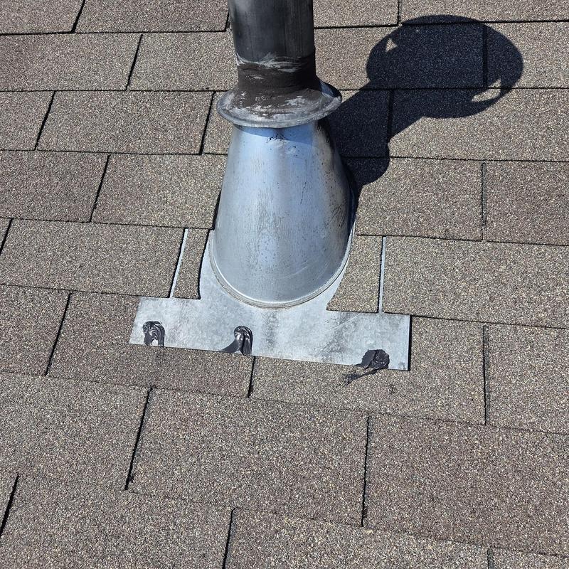 Roof vent flashing with caulk on asphalt shingles
