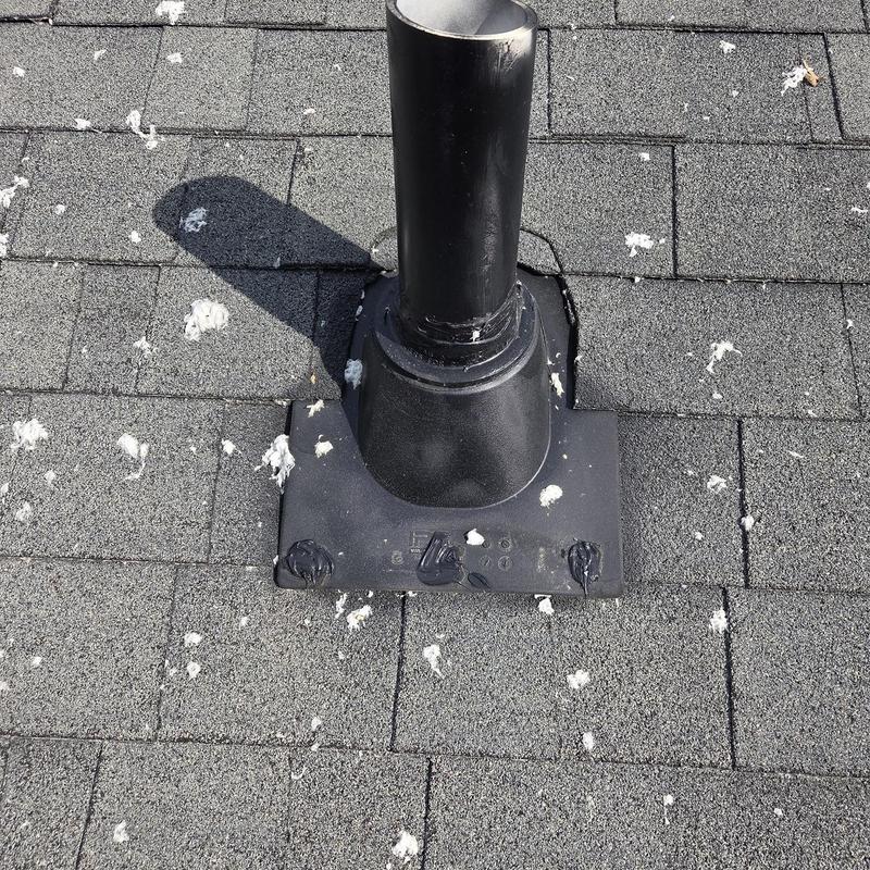 Roof vent pipe flashing with fresh caulking on shingles