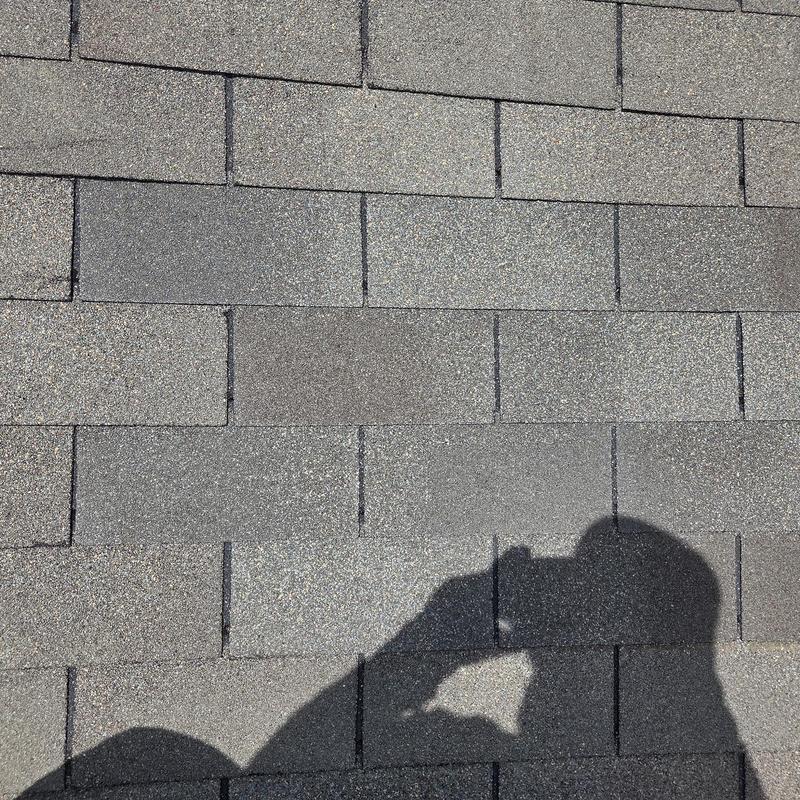 Roof shingles with shadow on repaired area