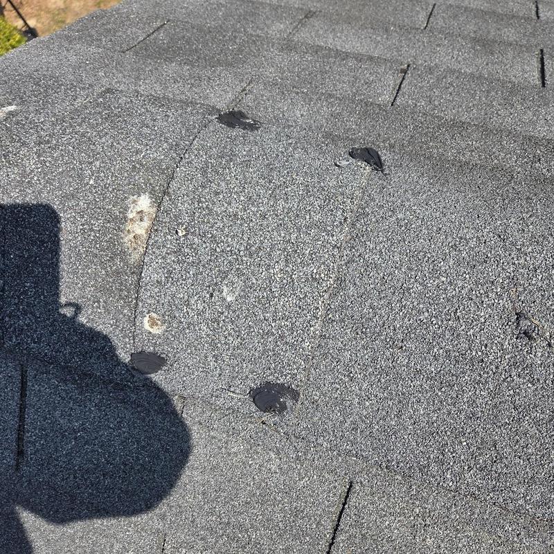 Roof shingles with caulked nail holes and damage patches