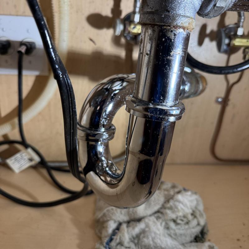 Chrome P-trap and drain pipes under kitchen sink