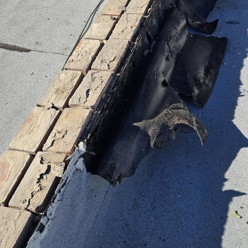 Roof membrane damage and cracked brick coping from storm