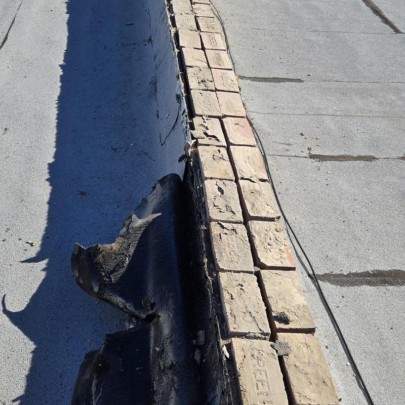 Flat roof membrane lifting and brick coping damage