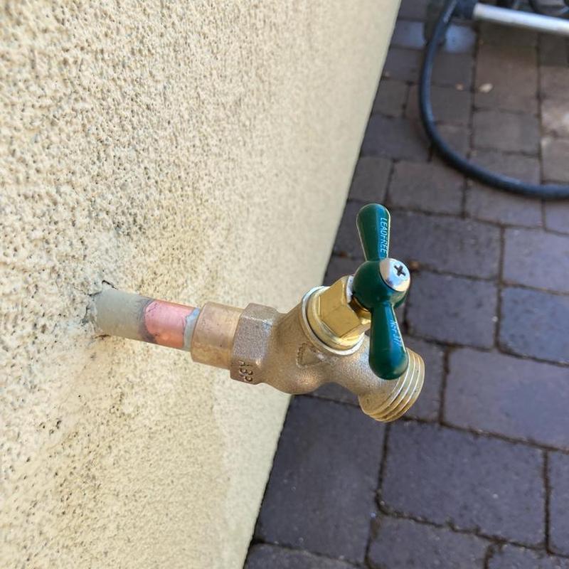 Outdoor hose bib installation on stucco wall