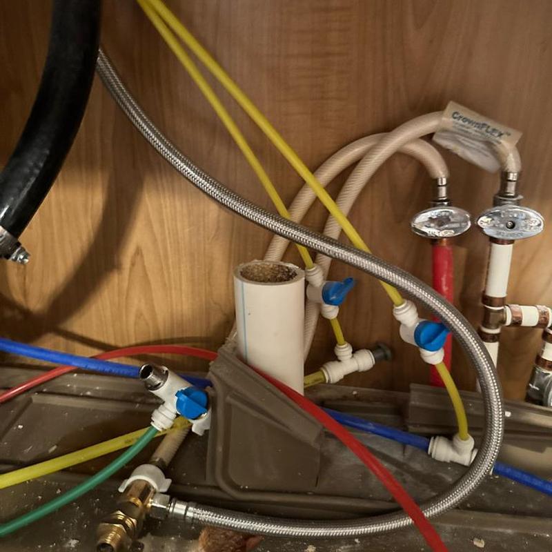 Reverse osmosis faucet plumbing under kitchen sink