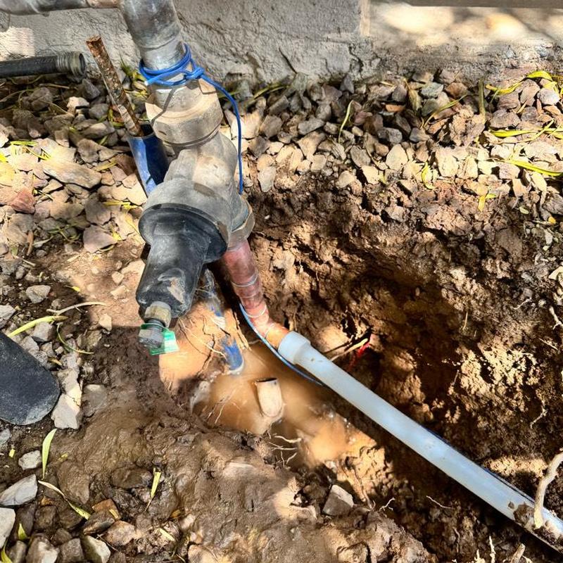 Main waterline leak with exposed copper pipe and PEX