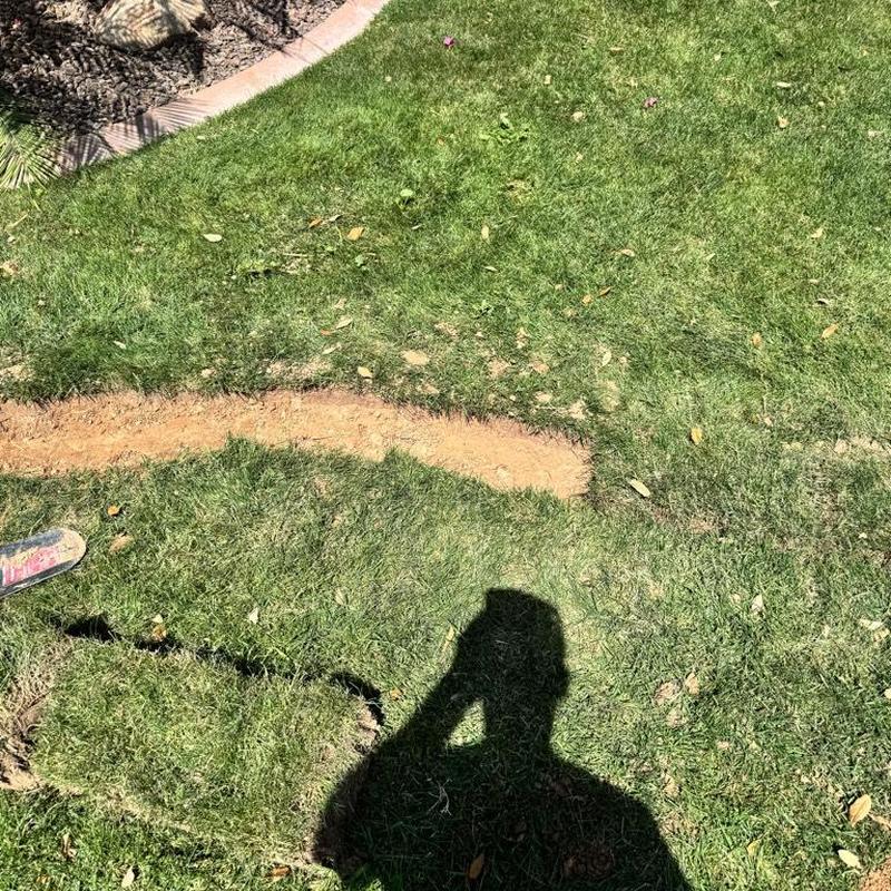 Main waterline trench with removed sod and exposed soil