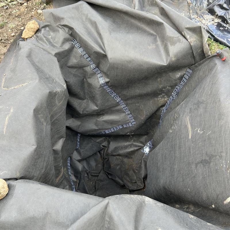 Sump pump discharge pit lined with protective fabric Sump pump discharge pit lined with protective fabric