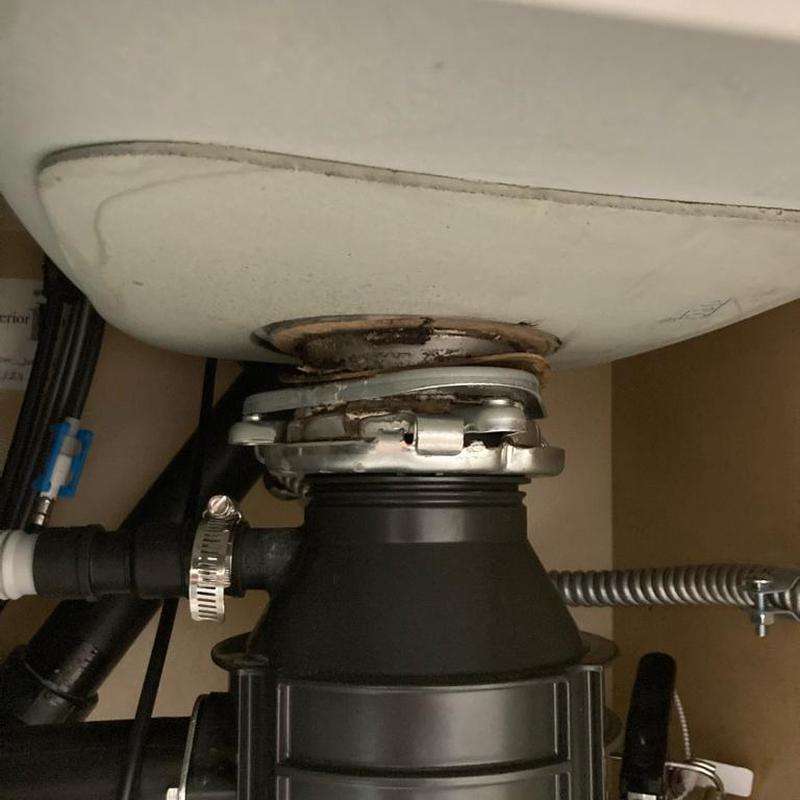 Disposal flange and sink drain seal under kitchen sink