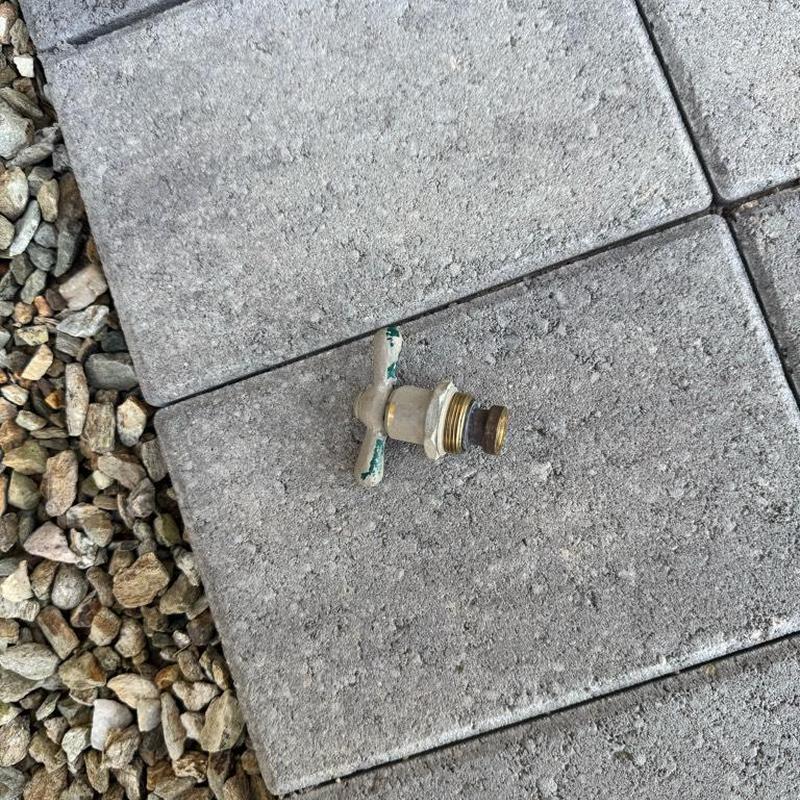 Hose bib handle and stem on concrete pavers