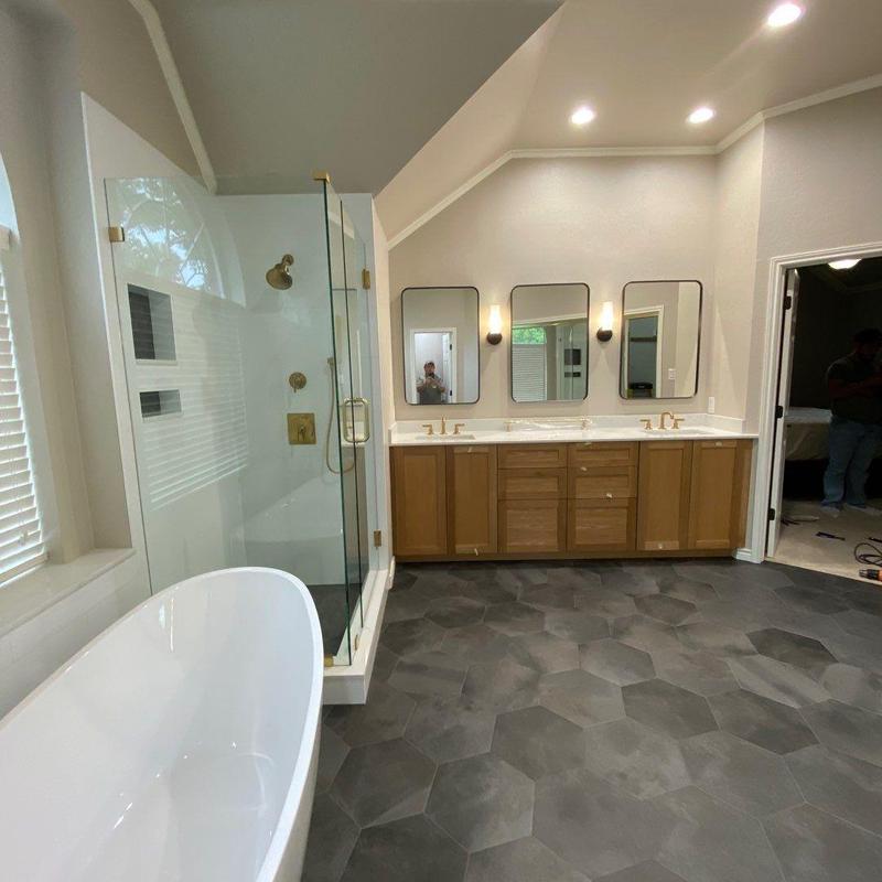Frameless shower enclosure with brushed brass fixtures