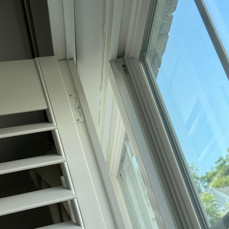 Window frame with sliding glass and interior shutters