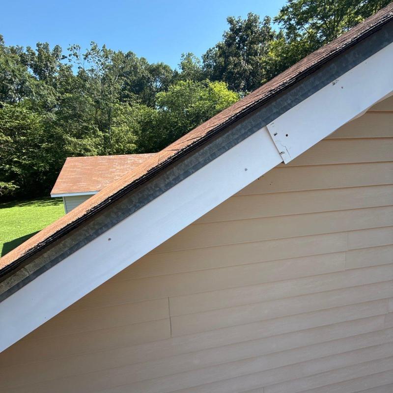 Roof shingles and flashing with hail damage on slope