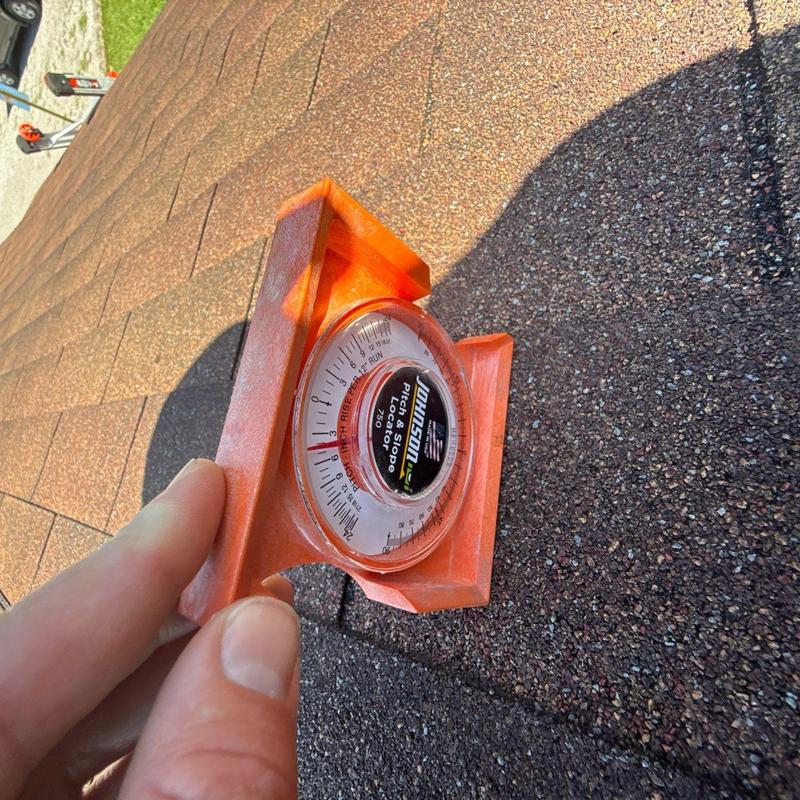 Roof shingle with pitch and slope measuring tool