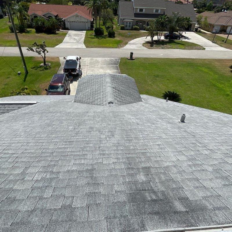 Shingle roof with vent pipes and driveway view