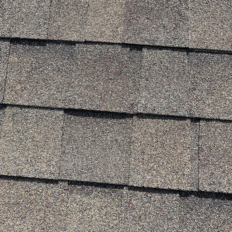 Asphalt shingles with hail damage on roof surface