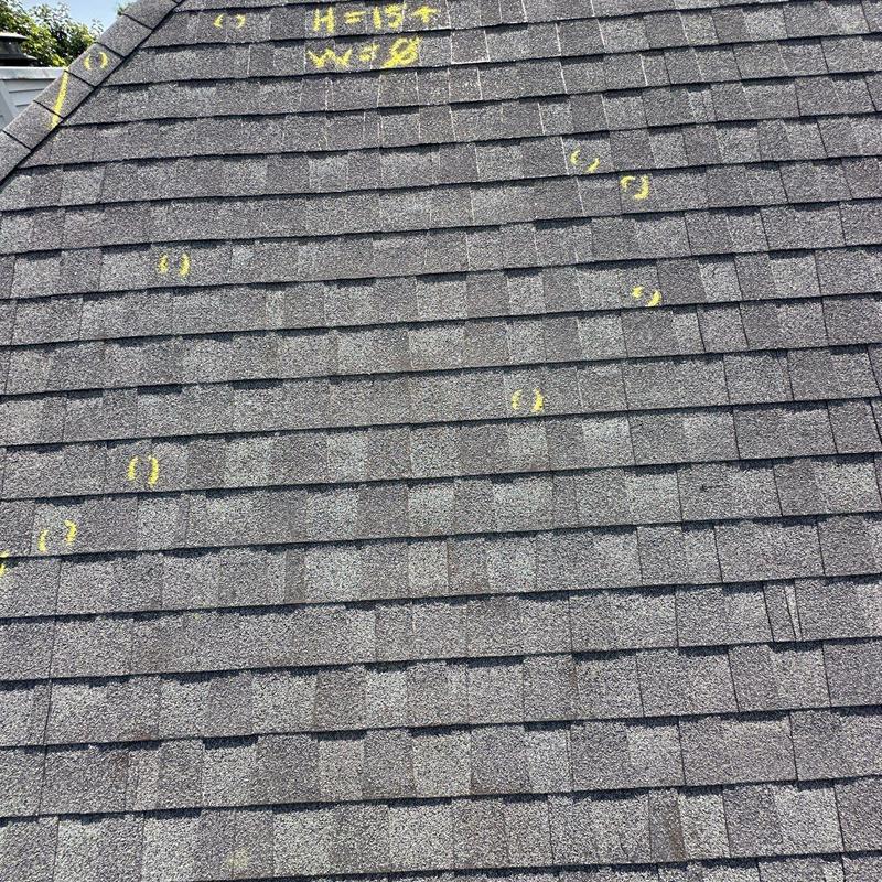 Roof shingles with hail damage marked in yellow chalk