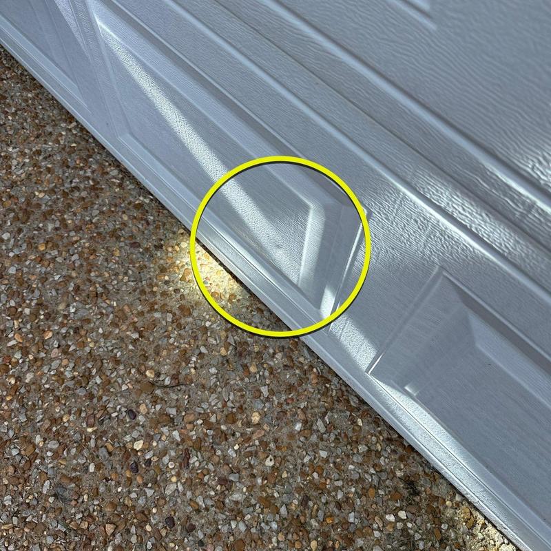 Garage door dent with surface damage close-up