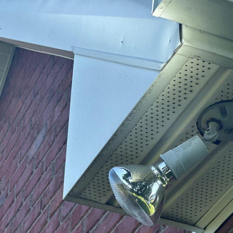 Outdoor floodlight fixture mounted under soffit trim