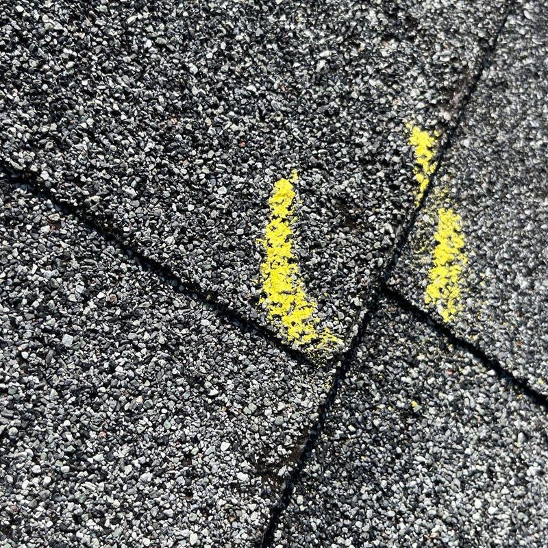 Asphalt shingles with marked hail damage spots