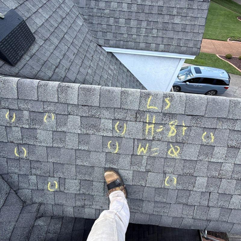 Roof shingles with hail damage marked for inspection
