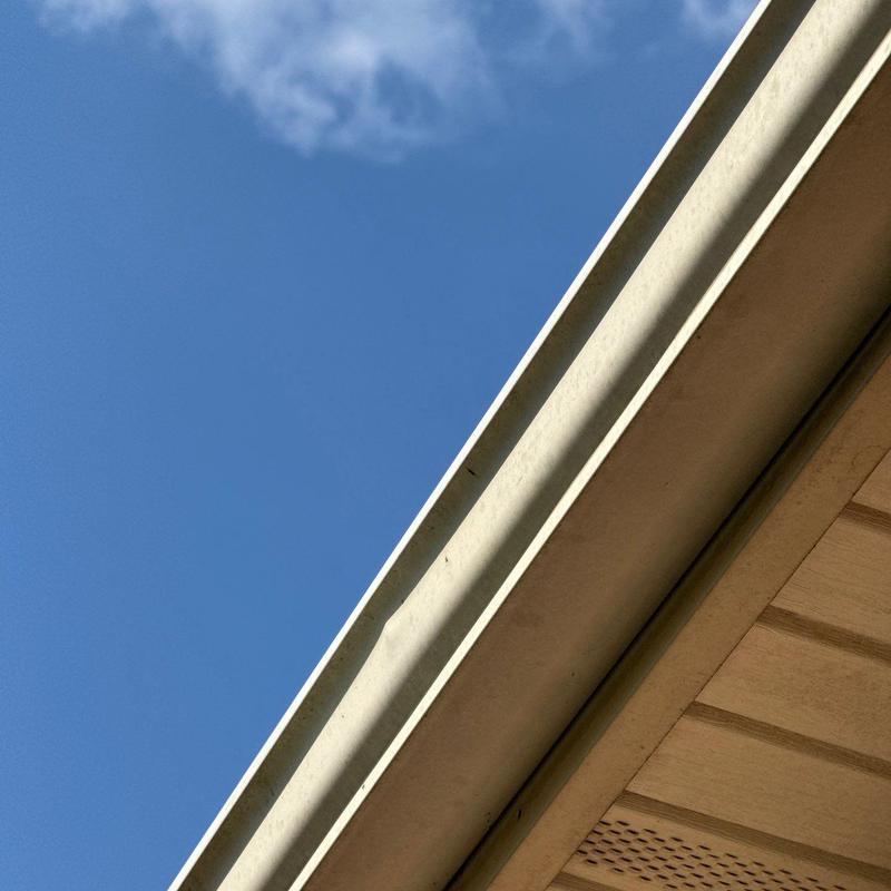 Rain gutter with slight bends on residential roof edge